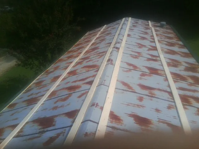 Rusted metal roof panels with new wood purlins before replacement — Storm Damage Roof Repair in Braddock by Roofing Brothers